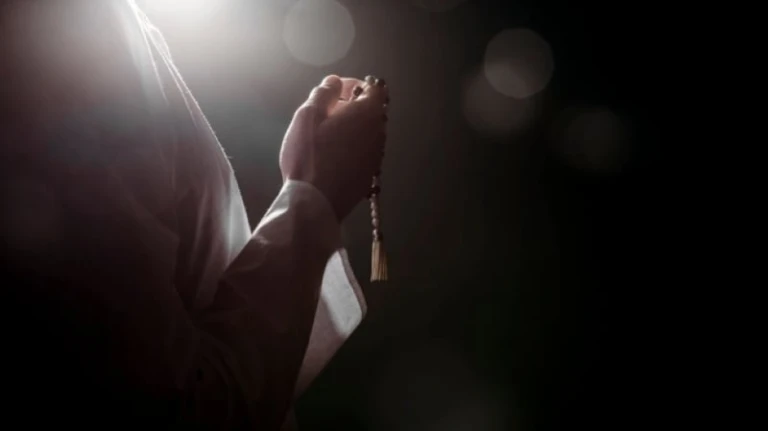 person holding prayer beads islam